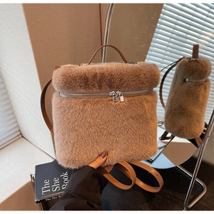 Detailed view of brown plush backpack with leather straps and silver zipper closure