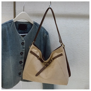 Dettaglio borsa hobo in camoscio beige con fibbia in pelle marrone e parti dorate