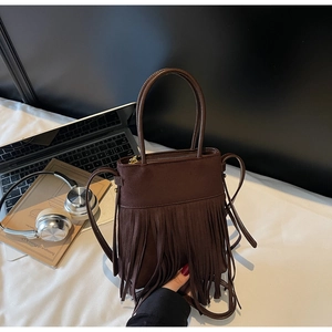 Détail du sac seau à franges marron foncé en daim au style rétro avec bandoulière fine