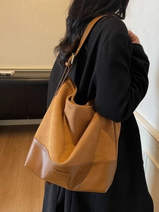 Vintage large camel suede tote bag worn over the shoulder with minimalist urban style