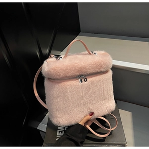 Close-up of pink plush backpack showing soft faux fur texture and silver metal zippers