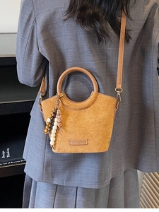 Vintage brown suede bucket bag with round handles and colorful beaded tassel detail