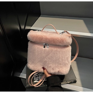 Detail of light pink plush backpack with soft faux fur texture and dual zipper closure