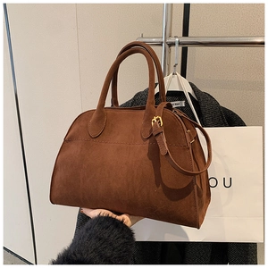 Dettaglio borsa Boston in camoscio marrone con tracolla regolabile e cuciture fini