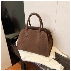 Dettaglio di una borsa tote in pelle scamosciata marrone scuro con finitura testurizzata