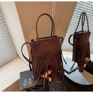 Détail du sac seau en daim marron avec longues franges et garnitures dorées polies
