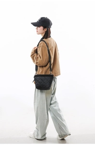Fashionable black quilted nylon bucket bag shown in a full minimalist streetwear outfit