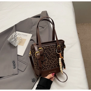 Detail view of vintage leopard print bucket bag with wooden bead tassel and leather strap