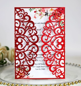Detail of red laser-cut glitter wedding invitation with elegant floral printed insert card