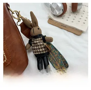 Detail of a brown knitted rabbit pendant with houndstooth outfit on a leather handbag