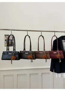 Detail view of stylish leather shoulder bags in four colors with cute bear pendants