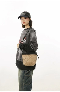Quilted khaki bucket bag with drawstring closure worn by model for casual street style