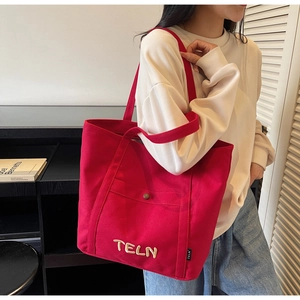 Détail du grand cabas en toile rouge avec broderie TELN et poche avant boutonnée