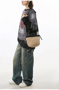 Detail view of khaki quilted bucket bag with black drawstring closure on fashion model