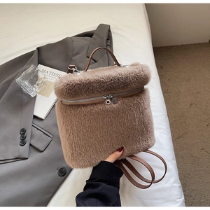 Detail of soft brown faux fur backpack with leather handles and silver zipper closure