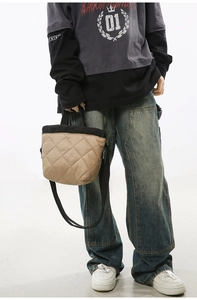 Close-up of khaki and black quilted nylon bucket bag showing textures and logo