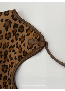 Détail de la texture léopard et de la bordure en cuir marron sur le sac cabas rétro
