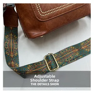 Detail of adjustable bohemian printed strap with gold buckle on brown leather bag