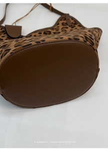 Vue détaillée du sac cabas léopard en daim avec base en cuir marron et surpiqûres