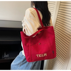 Détail du sac cabas en toile rouge avec broderie TELN 3D et bandoulière robuste