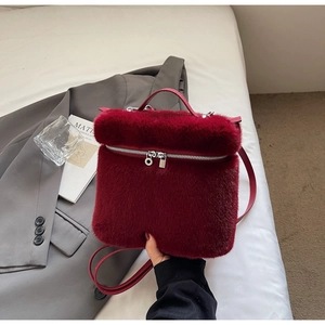 Detailed view of dark red faux fur bucket bag with leather strap and silver zipper