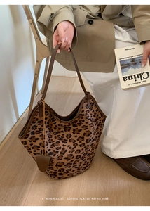 Détail du sac cabas en daim imprimé léopard avec anses en cuir et pendentif goutte