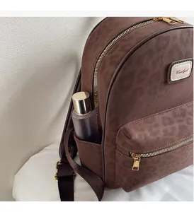 Close-up of leopard print details and side pocket holding a bottle on a brown backpack