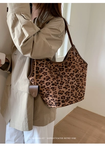 Détail du sac cabas léopard en daim avec bordure en cuir et breloque décorative