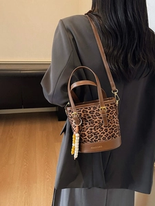 Chic leopard print bucket bag with brown leather trim and beaded tassel decoration