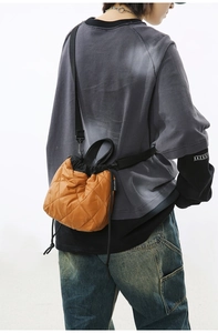 Close-up of caramel quilted bucket bag with drawstring closure and SHILAIEN label