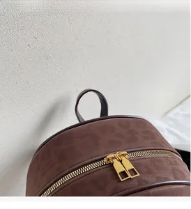 Detail of leopard print backpack featuring premium gold zippers and sturdy top handle