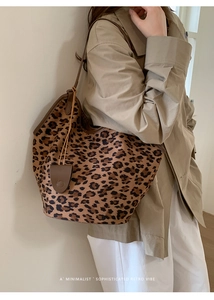 Détail du sac cabas léopard avec lanières en cuir marron et pochette assortie