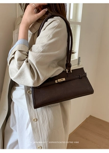 Macro view of dark brown leather handbag with gold metal lock and vintage buckle detail