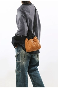 Close-up of orange quilted bucket bag with drawstring closure and texture detail