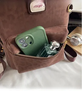 Close-up of brown suede leopard backpack front zipper pocket with phone and perfume