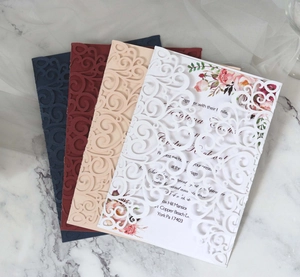 Detail of laser-cut lace wedding invitation with intricate European floral scrolls
