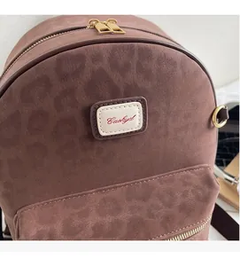 Close-up of brown leopard print suede backpack featuring Caskyd logo and gold zipper
