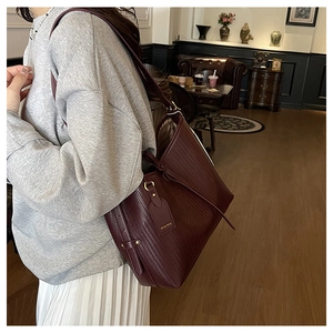 Borsa tote rosso vino profondo con trama intrecciata e targhetta dorata laterale