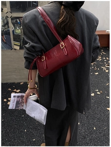 Gros plan du sac sous le bras vintage rouge vin avec boucles dorées en style de rue