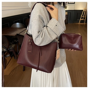 Dettaglio della borsa shopper bordeaux intrecciata con pochette coordinata