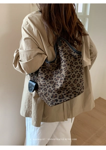 Détail du sac cabas léopard avec bordures en cuir noir et petite pochette amovible