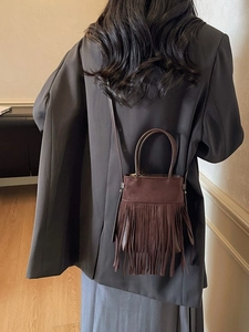Sac seau vintage marron en daim à franges avec poignée anneau et bandoulière porté