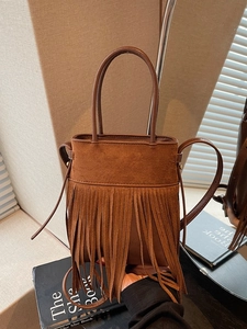 Sac seau vintage en daim marron avec de longues franges et des poignées élégantes