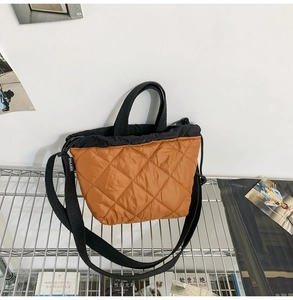 Detail of quilted brown nylon bucket bag featuring drawstring closure and black strap