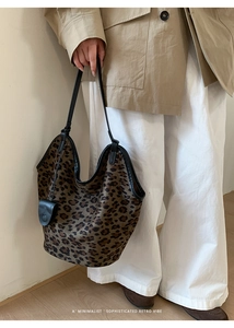 Détail du sac cabas léopard avec bordure en cuir noir et pochette accessoire