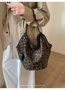 Détail du sac cabas en daim léopard porté avec un trench-coat kaki classique
