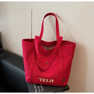 Détail du sac cabas en toile rouge avec broderie beige 3D et poche avant fonctionnelle