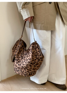 Détail du grand sac cabas léopard avec bordure en cuir marron et mini porte-monnaie