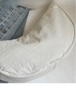 Close-up of white crescent crossbody bag showing crinkled nylon texture and sleek design