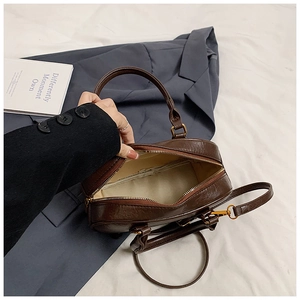 Detail view of the deep brown vintage handbag interior with soft beige fabric lining
